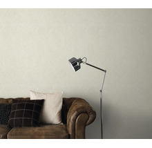 Woonkamer met gestructureerd vliesbehang, een bruine leren bank en een moderne vloerlamp voor een gezellige sfeer.