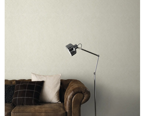 Woonkamer met gestructureerd vliesbehang, een bruine leren bank en een moderne vloerlamp voor een gezellige sfeer.