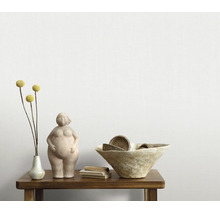 Decoratief beeldje van een vrouwenfiguur op een houten tafel met een schaal en een bloemenvaas als interieurdecoratie