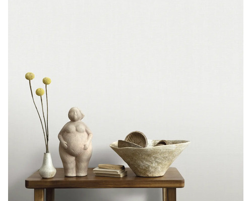 Decoratief beeldje van een vrouwenfiguur op een houten tafel met een schaal en een bloemenvaas als interieurdecoratie