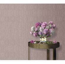Gestructureerd vliesbehang voor een muur met een boeket bloemen in een vaas op een ronde bijzettafel.