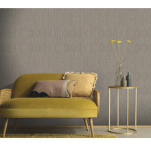 Gestructureerd behang in een woonkamer met een bank en bijzettafel voor een muur met verticale textuur.