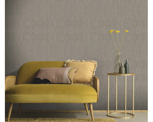 Gestructureerd behang in een woonkamer met een bank en bijzettafel voor een muur met verticale textuur.