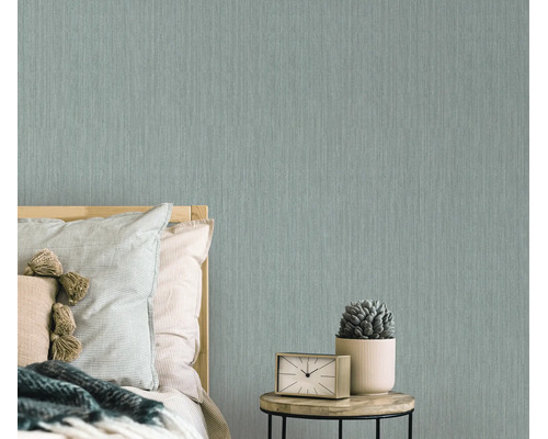 Moderne vliesbehang met subtiele textuur in een slaapkamer met nachtkastje en klok