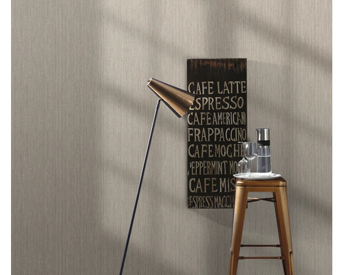 Gestructureerd vliesbehang in een moderne woonkamer met vloerlamp, barkruk en koffiebord.