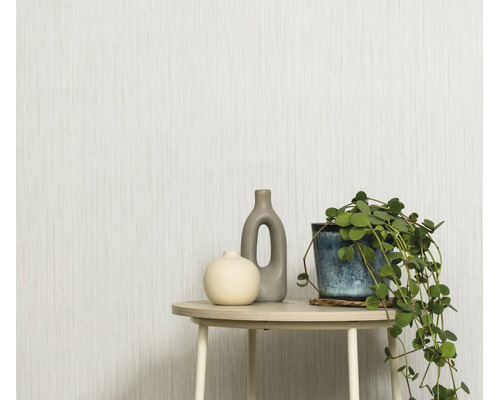 Gestructureerd behang met verticaal streepmotief in een lichte woonruimte met een bijzettafel, twee vazen en een hangplant.