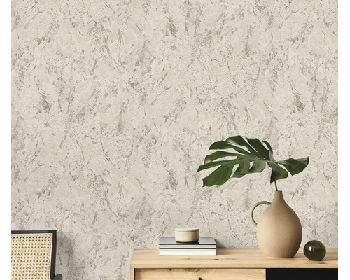 Gestructureerd vliesbehang met steenlook oppervlak in een kamer met houten dressoir en monstera plant als decoratie.