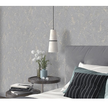 Modern behang met een gestructureerd oppervlak in een slaapkamer met nachtkastje, lamp en bed.
