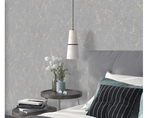 Modern behang met een gestructureerd oppervlak in een slaapkamer met nachtkastje, lamp en bed.