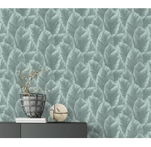 Vliesbehang met bladpatroon in moderne stijl op een woonkamermuur met dressoir decoratie