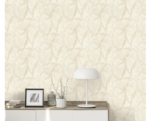 Vliesbehang met tropisch bladpatroon in een woonruimte met dressoir en tafellamp voor een muur met behangpatroon.