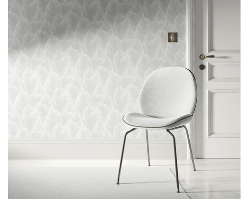 Modern behang met bladerpatroon in een lichte kamer met een elegante stoel en een kamerdeur.