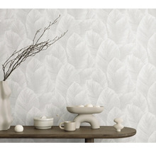 Behang met bladerpatroon in een modern ingerichte kamer met houten console en decoratievoorwerpen