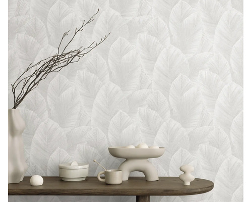 Behang met bladerpatroon in een modern ingerichte kamer met houten console en decoratievoorwerpen