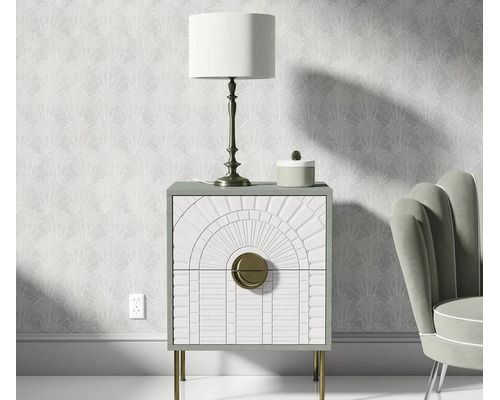 Nachtkastje met twee lades, gestructureerde fronten en metalen poten, geplaatst voor een behang met patroon in een slaapkamer.