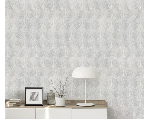 Gestructureerd behang met waaiervormig bladerpatroon in een moderne woonkamer met dressoir en tafellamp