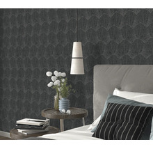 Gestructureerd vliesbehang met waaierbladerpatroon in een slaapkamer aan een muur achter een bed met nachtkastjes.