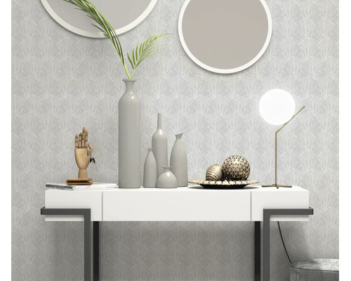 Vliesbehang met waaiervormig patroon in een modern ingerichte woonkamer met een witte console, ronde spiegels en decoratieve vazen.