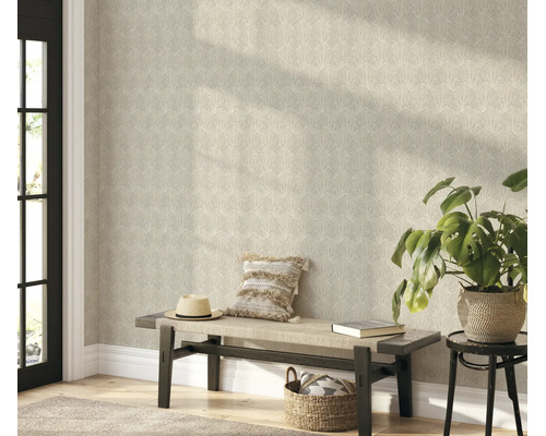 Woonruimte met vliesbehang met ginkgo bladmotief op de muur, een houten bank met kussens en een kamerplant.