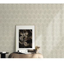 Gestructureerd vliesbehang met waaierpatroon als wanddecoratie in een woonkamer met fotolijst en decoratief figuur op een zitmeubel.