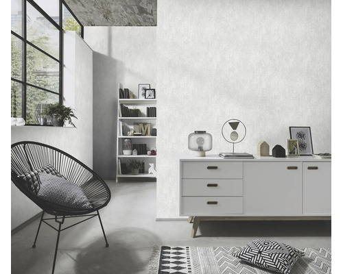 Woonkamer met gestructureerd vliesbehang, modern dressoir, stoel met draadframe en open wandrek in minimalistische woonstijl.