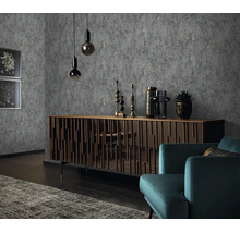 Woonkamer met vliesbehang met steenlook, houten dressoir met verticale latten, twee hanglampen, decoratie en een moderne fauteuil.