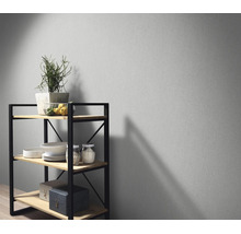 Een gladde, effen muurafwerking met een modern rek van metaal en hout, gedecoreerd met planten, schalen en opbergdozen.