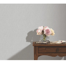 Getextureerd behang in een interieur met een bloemenvaas op een houten tafel