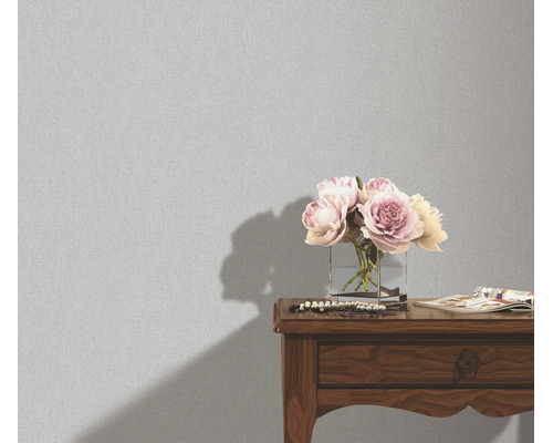 Getextureerd behang in een interieur met een bloemenvaas op een houten tafel