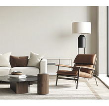 Moderne woonkamer met leren fauteuil bank salontafel vloerlamp en vloerkleed in een lichte en stijlvolle kamer.