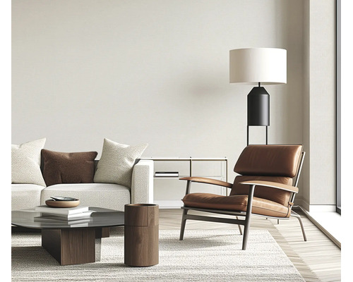 Moderne woonkamer met leren fauteuil bank salontafel vloerlamp en vloerkleed in een lichte en stijlvolle kamer.
