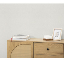 Gestructureerd vliesbehang voor een houten dressoir met boeken en fotolijst in een modern interieur.