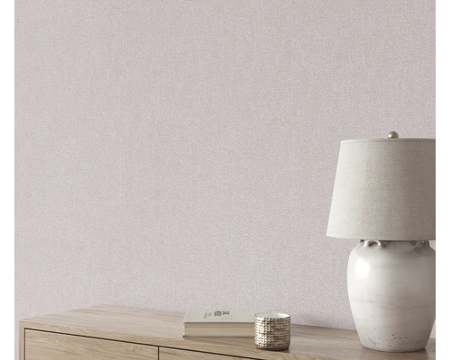 Vliesbehang met fijne structuur voor een muur, gedecoreerd met een tafellamp en een boek op een houten dressoir.