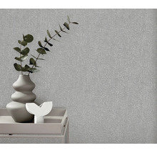 Gestructureerd vliesbehang in een moderne woonomgeving met een vaas en planten op een bijzettafel