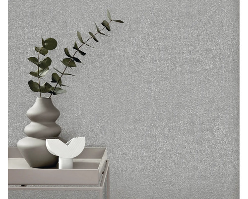 Gestructureerd vliesbehang in een moderne woonomgeving met een vaas en planten op een bijzettafel