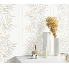 Vliesbehang met bladerenpatroon in een modern ingerichte woonomgeving met decoratieve objecten op een dressoir.