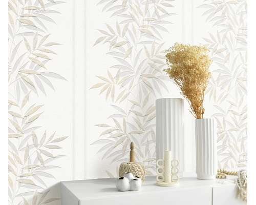 Vliesbehang met bladerenpatroon in een modern ingerichte woonomgeving met decoratieve objecten op een dressoir.