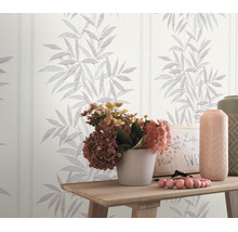 Vliesbehang met bloemrijk bladerpatroon in een woonruimte met houten tafel en bloemendecoratie