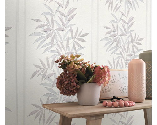 Vliesbehang met bloemrijk bladerpatroon in een woonruimte met houten tafel en bloemendecoratie