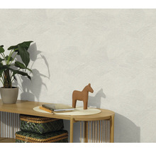 Gestructureerd vliesbehang op een muur met een console, plant en decoratie in een lichte woonruimte.