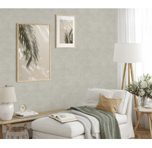 Woonkamer met gestructureerd vliesbehang, ingericht met twee ingelijste palmfoto’s, een chaise longue en een vloerlamp in een licht design.