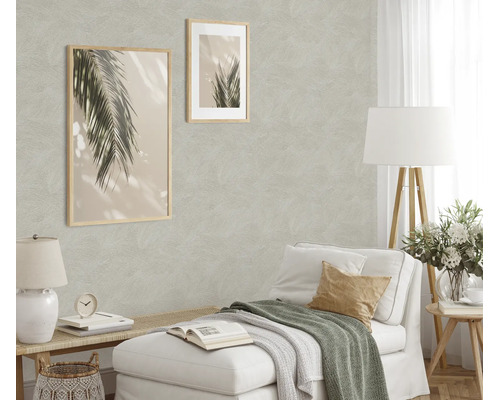Woonkamer met gestructureerd vliesbehang, ingericht met twee ingelijste palmfoto’s, een chaise longue en een vloerlamp in een licht design.