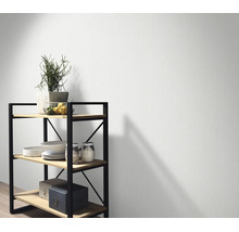 Gestructureerd vliesbehang voor een muur met een rek van hout en metaal in een modern ingerichte kamer.