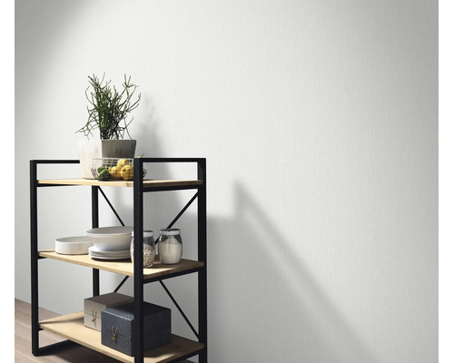 Gestructureerd vliesbehang voor een muur met een rek van hout en metaal in een modern ingerichte kamer.