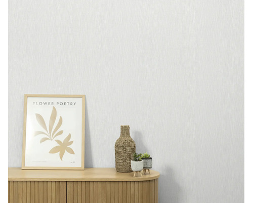 Gestructureerd vliesbehang voor een muur met een houten kast, een ingelijste afbeelding en kleine planten.