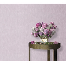 Gestructureerd behang met subtiele textuur in een interieur, inclusief een bijzettafel met een boeket pioenrozen.