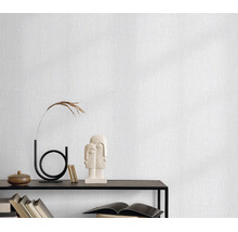 Gestructureerd behang met fijne verticale lijnen, gepresenteerd in een minimalistische woonomgeving.