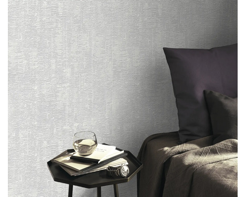 Gestructureerd vliesbehang met subtiele lijnen aan een wand in een modern ingerichte slaapkamer met een bijzettafel.