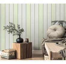 Vliesbehang met verticaal streepmotief in een woonkamer met houten tafel en decoratie.