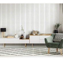 Woonkamer met verticaal gestreept behang, wit dressoir en een groene fauteuil in een moderne Scandinavische stijl.